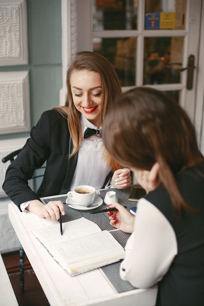 lindas e elegantes jovens empresárias sentado em um café e trabalhando