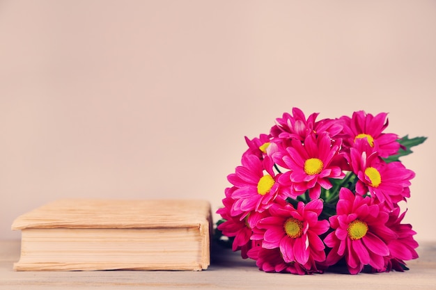 Lindas flores com livro sobre fundo claro