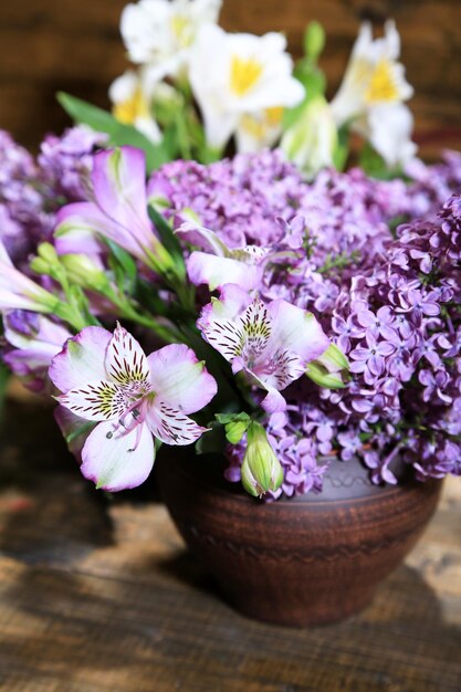 Lindas flores da primavera em vaso com fundo de madeira