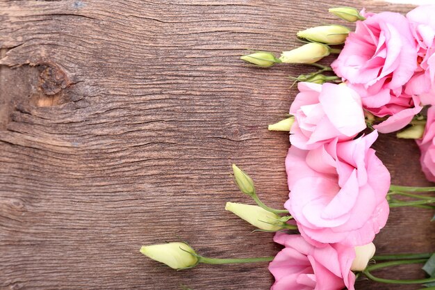 Lindas flores de eustoma em fundo de madeira