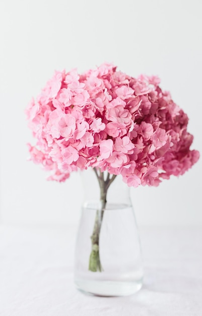 Lindas flores de hortênsia rosa em um vaso em uma mesa