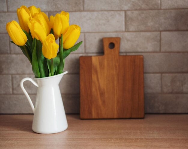 Lindas flores de tulipa na mesa na cozinha