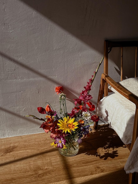 Lindas flores em vaso à luz do sol no fundo da cadeira retrô moderna e parede rural Flores elegantes natureza morta em composição artística em casa Estética de buquê de verão