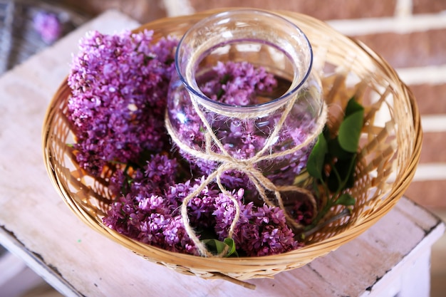 Lindas flores lilás em um vaso, em uma escada de madeira, na cor do fundo da parede