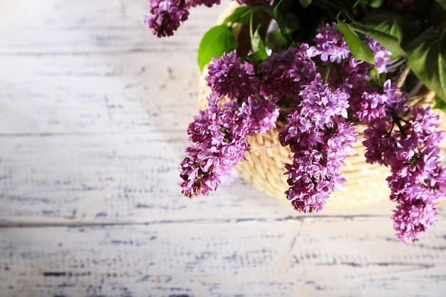 Lindas flores lilás em vaso na cor de fundo de madeira