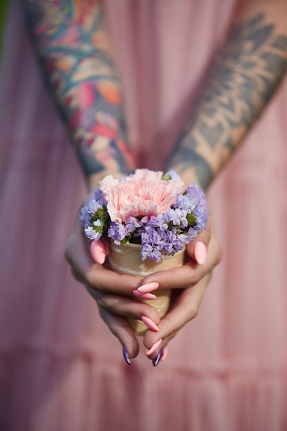 Lindas flores na menina de mãos com tatuagens