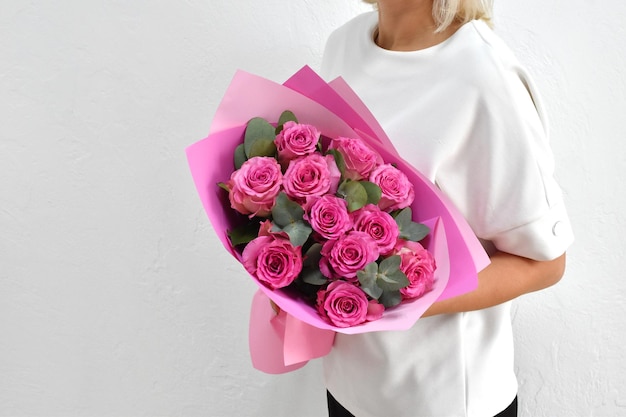 Lindas flores para férias Mulher com lindas flores nas mãos dentro de casa buquê de flores para floricultura