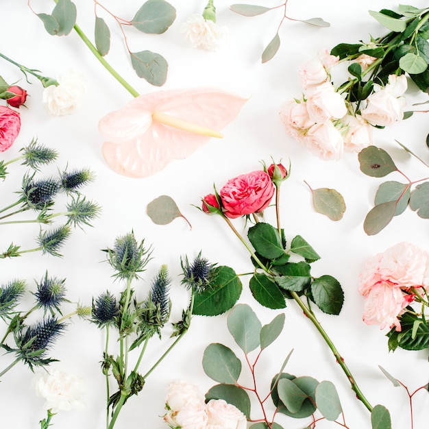 Lindas flores: rosas, eringium, flor de antúrio, eucalipto em branco.