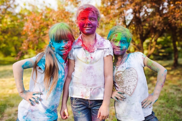 Lindas garotas europeias celebram o festival indiano de holi com tinta colorida em pó no rosto e no corpo