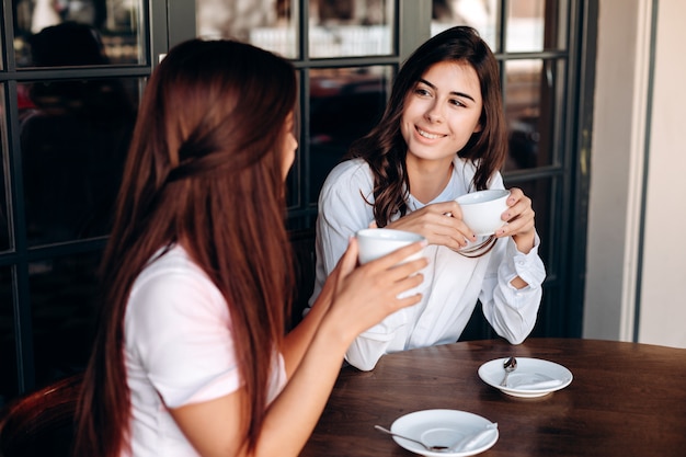 Lindas garotas tomando café durante um almoço de negócios em um café