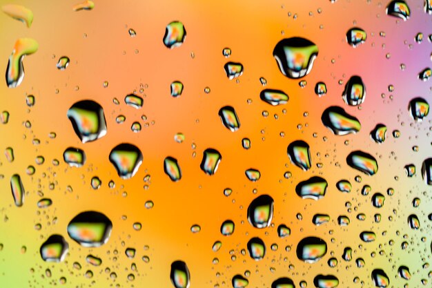 Lindas gotas de água multicoloridas em um copo