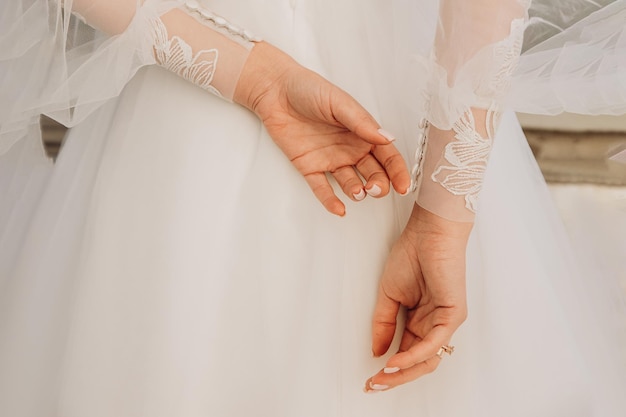 Lindas mãos da noiva na frente do vestido estilo branco