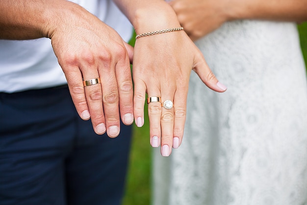 Lindas mãos de recém-casados exibindo suas alianças