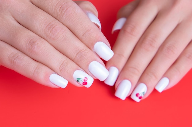 Lindas mãos femininas com unhas de manicure brancas