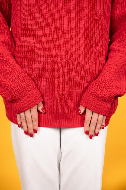 Lindas mãos femininas com unhas vermelhas sobre fundo tricotado Vista recortada da mulher com os braços para baixo