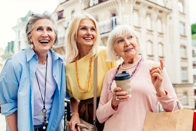 Lindas mulheres idosas felizes fazendo compras no centro da cidade