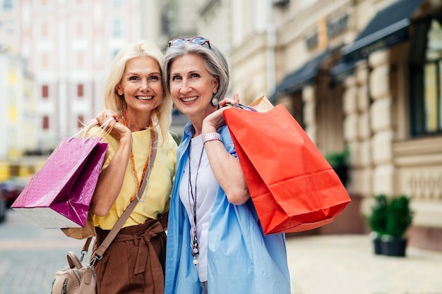 Lindas mulheres idosas felizes fazendo compras no centro da cidade