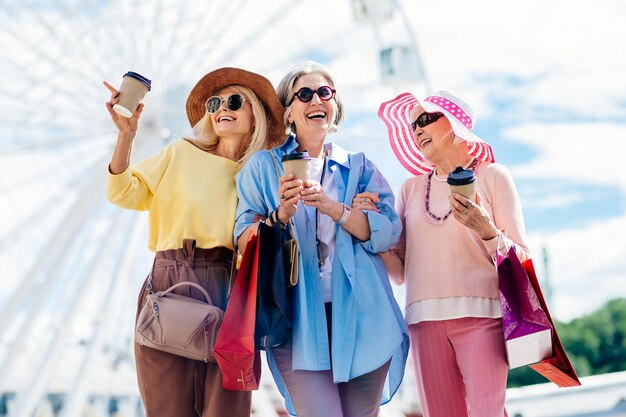 Lindas mulheres idosas felizes fazendo compras no centro da cidade