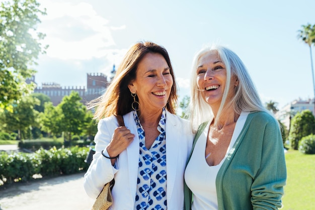 Lindas mulheres idosas se unindo ao ar livre na cidade Amigas maduras e alegres e atraentes se divertindo fazendo compras e criando conceitos sobre o estilo de vida dos idosos