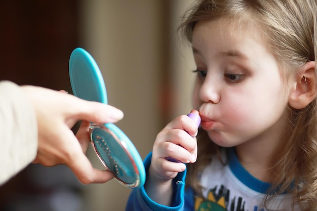 Foto lindas niñas jugando con cosméticos en casa