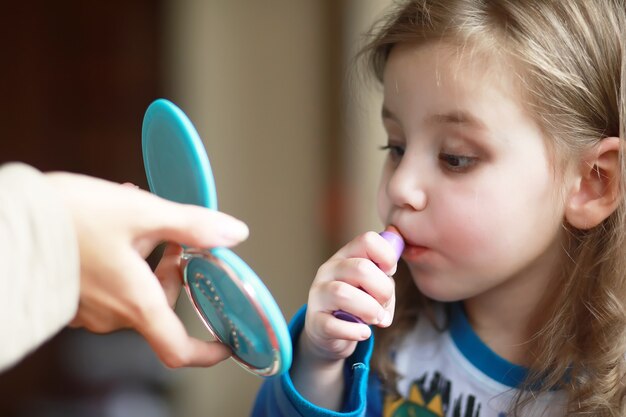 Lindas niñas jugando con cosméticos en casa