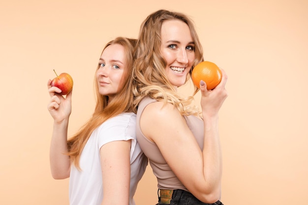 Lindas novias sonriendo con un concepto de comida naranja saludable