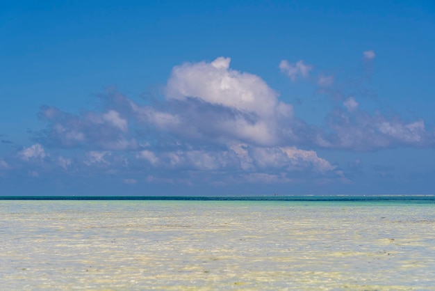 Lindas nuvens brancas e céu azul sobre ondas de água do mar na ilha de Zanzibar Tanzânia África Conceito de viagem e natureza