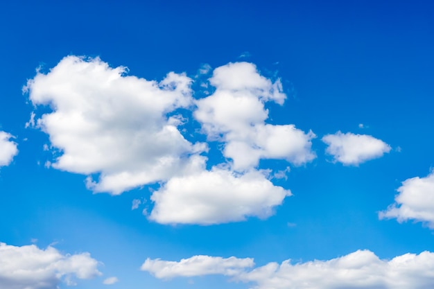 Lindas nuvens brancas e fofas flutuam lentamente contra o céu azul em um dia quente e ensolarado de verão