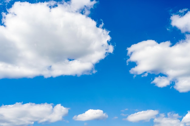 Lindas nuvens brancas e fofas flutuam lentamente contra o céu azul em um dia quente e ensolarado de verão