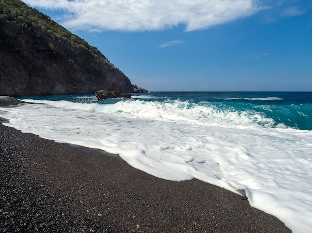 Lindas ondas de espuma em um dia ensolarado no Mar Egeu, na ilha de Evia, na Grécia