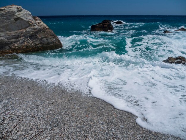 Lindas ondas de espuma em um dia ensolarado no Mar Egeu na ilha na Grécia