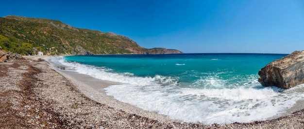 Lindas ondas espumosas na praia no mar Egeu, na Grécia