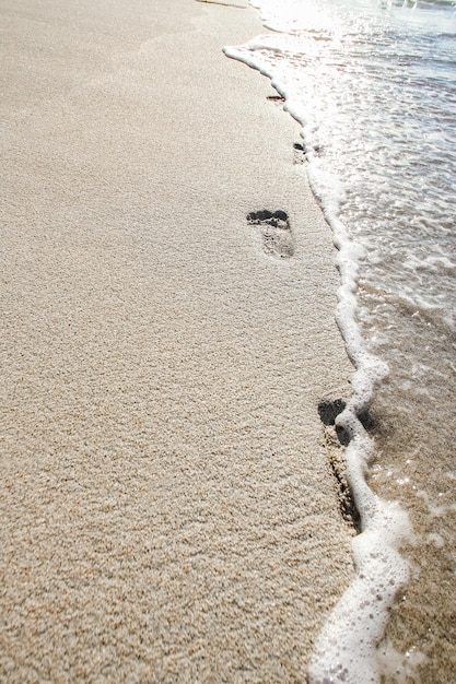 Lindas pegadas com pés no fundo de areia