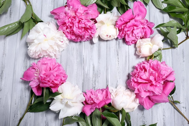 Lindas peônias rosa e brancas na cor de fundo de madeira