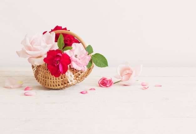 Lindas rosas na cesta na mesa de madeira