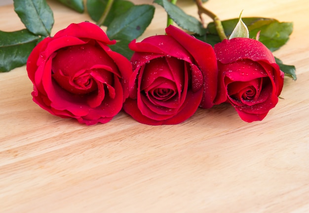 Lindas rosas vermelhas na mesa de madeira