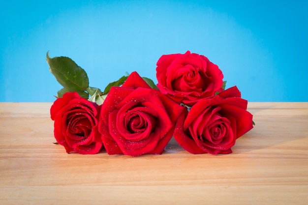 Lindas rosas vermelhas na mesa de madeira