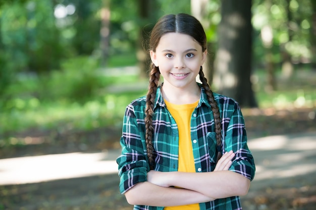 Las lindas trenzas de Girl Scouts usan ropa a cuadros, el fondo de la naturaleza, el concepto de senderismo