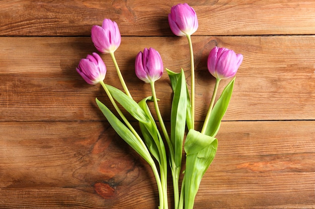 Lindas tulipas lilás em fundo de madeira