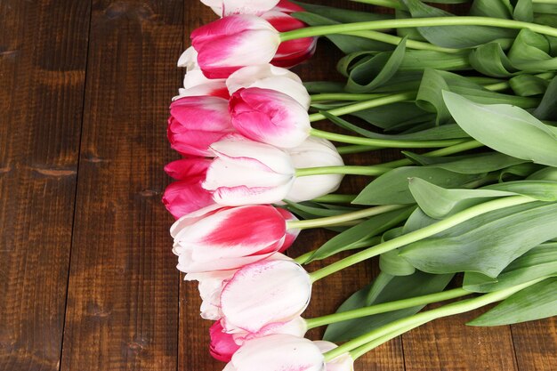 Lindas tulipas na cor de fundo de madeira