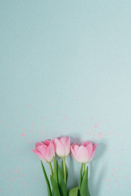 Lindas tulipas rosa primavera sobre um fundo claro de hortelã com lantejoulas rosa leigos. Uma cópia do espaço. Cartão de dia dos namorados, aniversário, aniversário, 8 de março, Páscoa