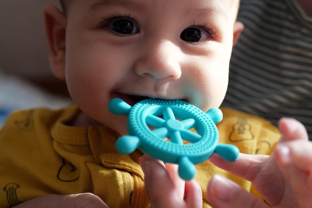 Foto lindo adorable bebé recién nacido jugando con colorido juguete sonajero bebé con mordedor retrato de bebé encantador de seis meses en blanco con juguete mordedor