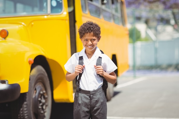 Foto lindo alumno sonriendo a la cámara en el autobús escolar