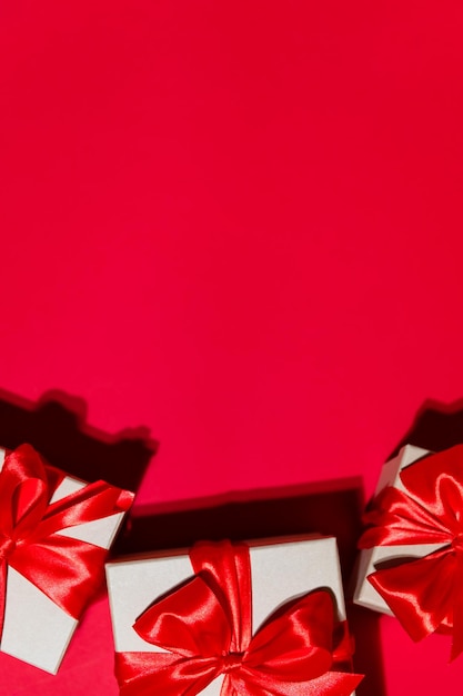 Lindo banner vertical festivo de natal ou cabeçalho de férias presentes em fundo vermelho caixas de presente de natal na temporada de férias vermelha ano novo copiar espaço para texto