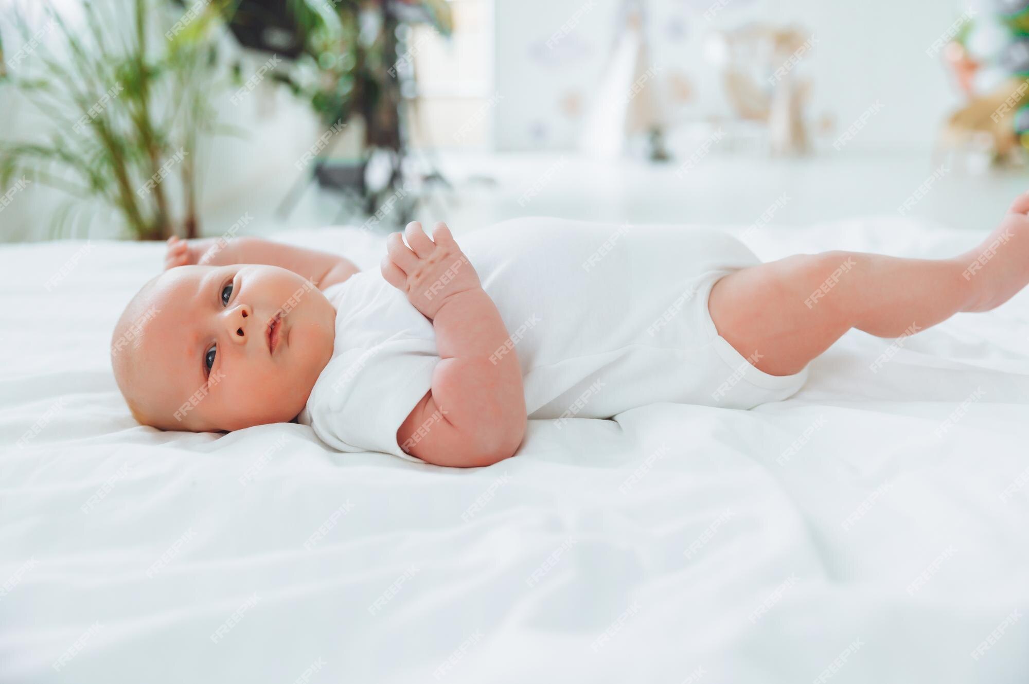 Lindo bebé de 2 meses acostado en la cama ropa de natural delicada piel bebé Foto Premium