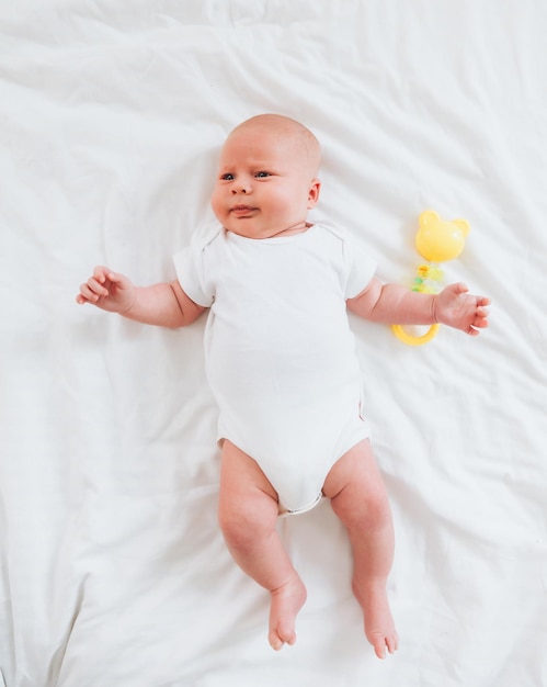 Lindo bebé de 2 meses acostado en la cama ropa de cama natural delicada piel de bebé