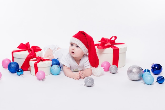 Lindo bebé acostado boca abajo en una gorra de año nuevo entre Christm