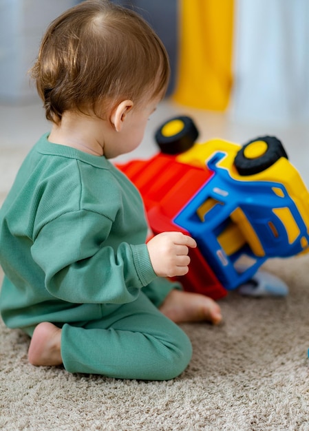 Lindo bebé alegre jugando con juguetes coloridos en casa Niño jugando con juguetes educativos