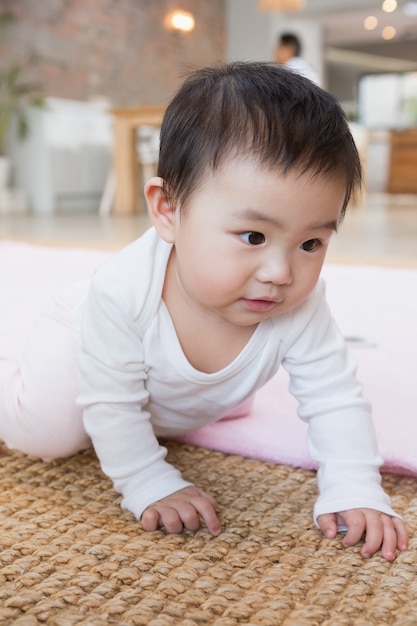 Lindo bebe en la alfombra en casa