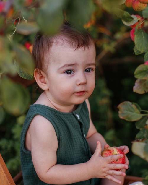 Lindo bebé de un año en el huerto de manzanas